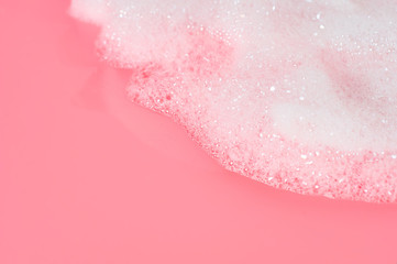 Obraz premium Foam bubbles on pink background. Cleaning service. Concept of froth party