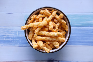 Bowl with tasty potato chips on wooden background .