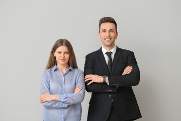 Businessman and his beautiful secretary on light background