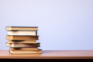 Stack of books on the table on a blue background. learning concept. literature.
