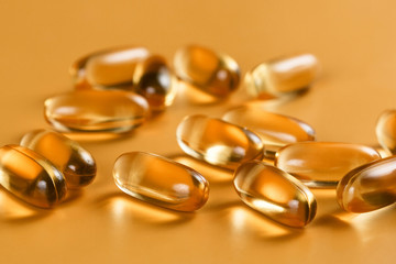 Many capsules Omega 3 on yellow background. Close up, high resolution product. Health care concept.