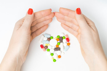 women's hands and heart-shaped tablets