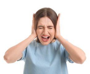 Young woman suffering from loud noise on color background