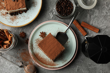 Composition with tiramisu, coffee and cinnamon on gray table