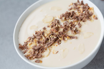 Delicious Breakfast with yogurt, chocolate and almond flakes, close-up.