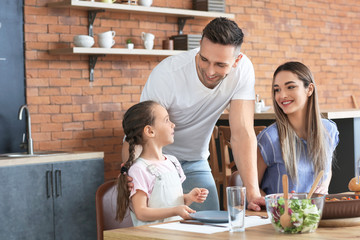 Happy family having dinner together in kitchen