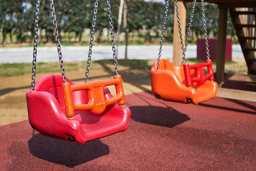 Swings on the playground in the children park - obrazy, fototapety, plakaty