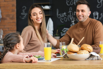 Happy family having dinner together in kitchen