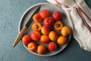 Composition with tray of apricots on cement background