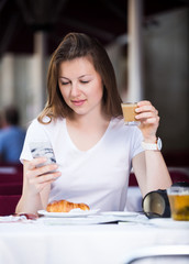Tourist using mobile phone in cafe