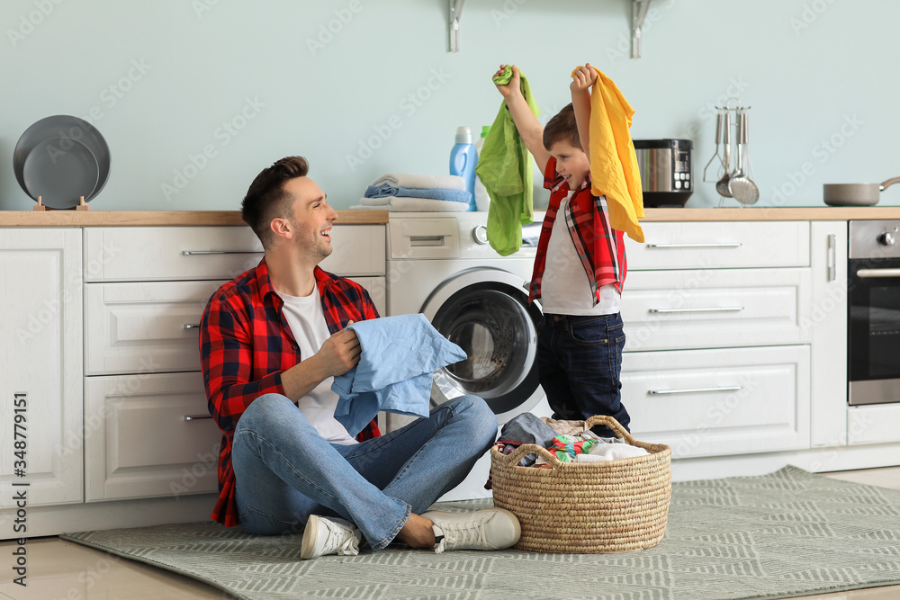 Poster Man and his little son doing laundry at home