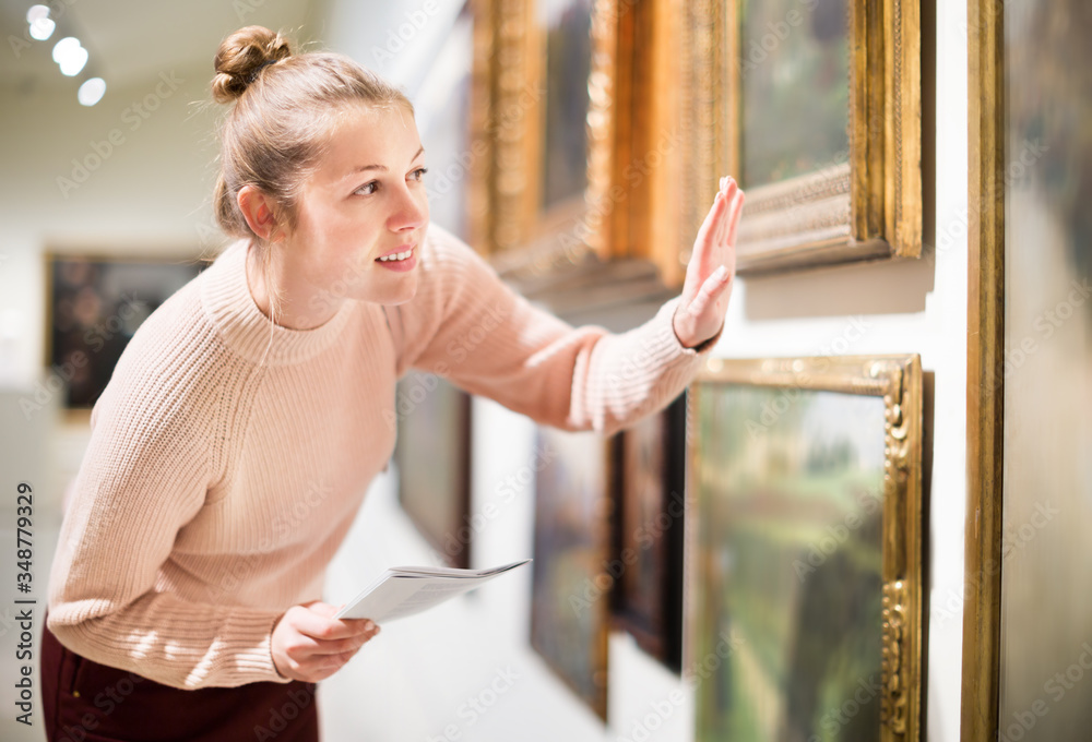 Wall mural woman with guide looking at pictures in museum