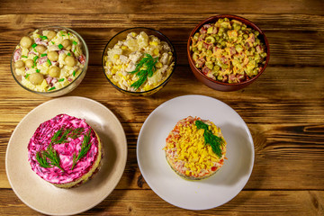 Set of festive mayonnaise salads on wooden table. Top view
