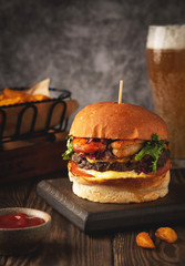Shrimp and beef burger, beer glass, fried potato wedges and sause. Close-up, copy space.
