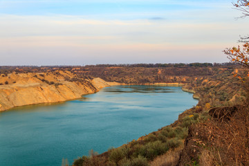 View of a lake with sandy shores in flooded sand quarry