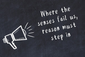 Chalk loudspeaker and wise quote on black desk © iushakovsky