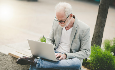 Mature businessman using laptop outdoors