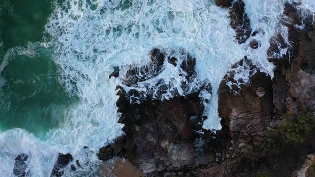 Waves crashing on headland rocks. Sunshine Coast, Coolum, Queensland, Australia.