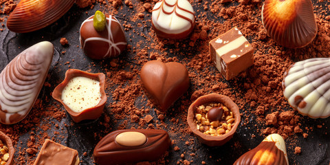 Fototapeta na wymiar Belgian chocolate assortment panorama, various bonbons on a dark background