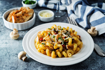 Roasted chicken mushroom pepper pasta in a white plate