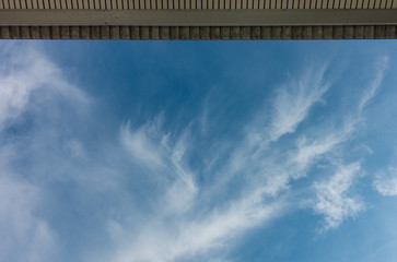 Clear blue sky with partly cloudy and a ceiling of the roof on top. Copy space and background.