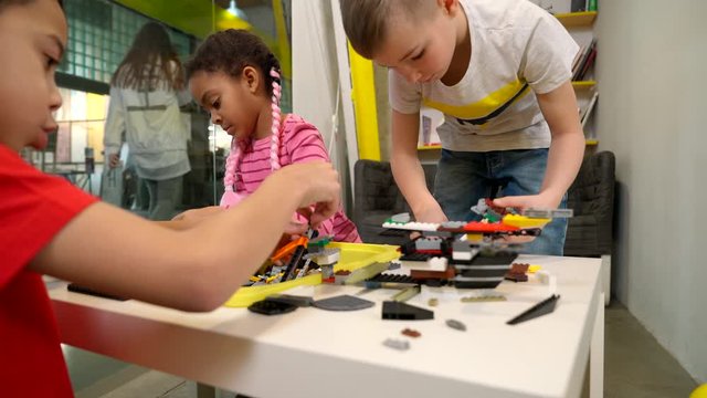 Kids using building kit to create toys.