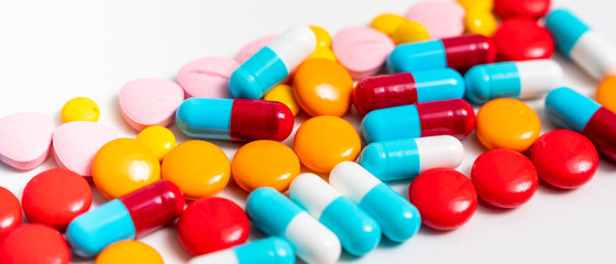 A lot of pills colorful on the white background. Medicine pills, tablets and capsules.