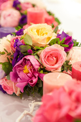 wedding table decoration bouquets of flowers, candles and dyed branches