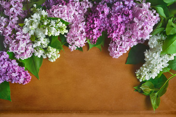 Decorative lilac flowers on wooden surface. Spring or floral background.