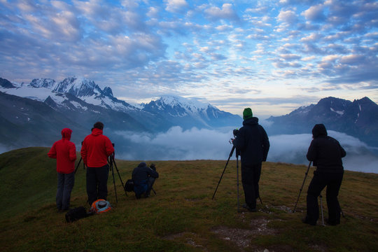 Photographers stay on lake and takes photos. Dreamy  mountains, orange sunrise in a beautiful valley. 
Colorful summer view of the Lac Blanc lake with Mont Blanc (Monte Bianco), Alps on background.