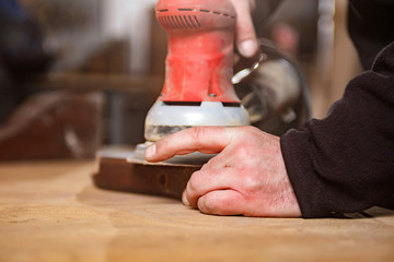 Male carpenter working on old wood in a retro vintage workshop.