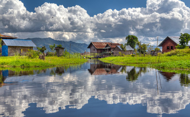 Dramatic Clouds Reflection with a farmer house in Inle Lake Myanmar