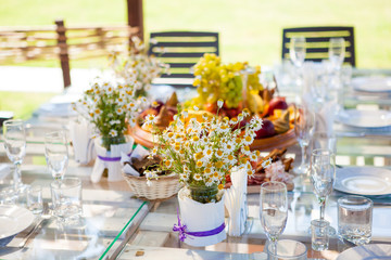 table set dishes and decorated with an armful of daisies