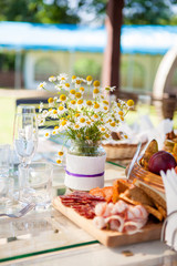 table set dishes and decorated with an armful of daisies
