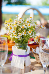 table set dishes and decorated with daisies