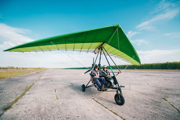 Moto hang-glider takes off on a ground airfield. - obrazy, fototapety, plakaty