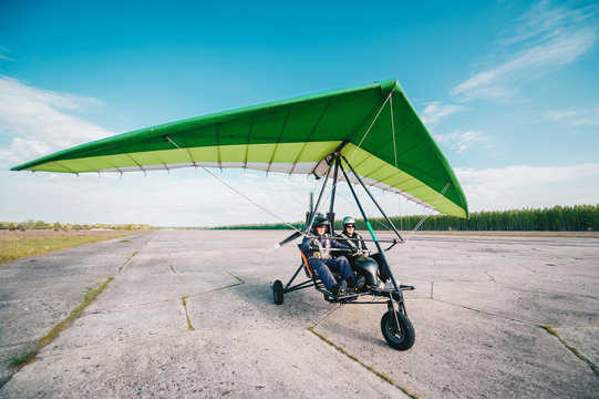 Moto hang-glider takes off on a ground airfield.