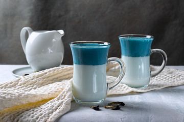 Dalgona Matcha Blue Latte, matcha cream in a glass cup on a light gray background. Horizontal orientation