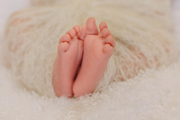legs of a newborn in lace fabric