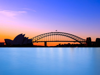Fototapeta na wymiar Panoramic view of Sydney Harbour with all the vibrant colours on a orange and blue sunset afternoon 