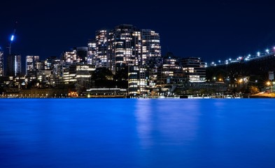 Fototapeta premium long night exposure of Sydney Australian Harbour showing the vibrant colours of the lights on the water