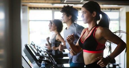 Group of young people exercising on a treadmill at gym