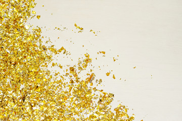 Golden confetti scattered on a white table.