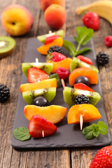 Fototapeta na wymiar fruit dessert skewer with apricot, berry fruit, kiwi and banana