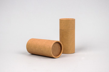 Paper tubes on grey background with copyspace - cardboard packaging for natural cosmetics and...