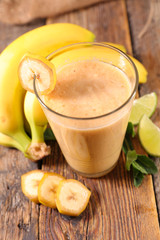 smoothie with banana on wood background