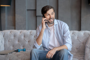 Young man sitting on a sofa with a smartphone.