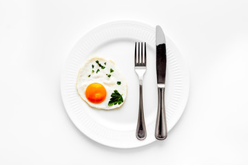 Fried eggs on plate - white kitchen table top view