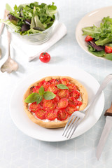 plate of tomato quiche with salad