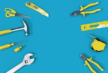 Naklejka premium Many yellow hand tools on a blue background, there is space for your ad.